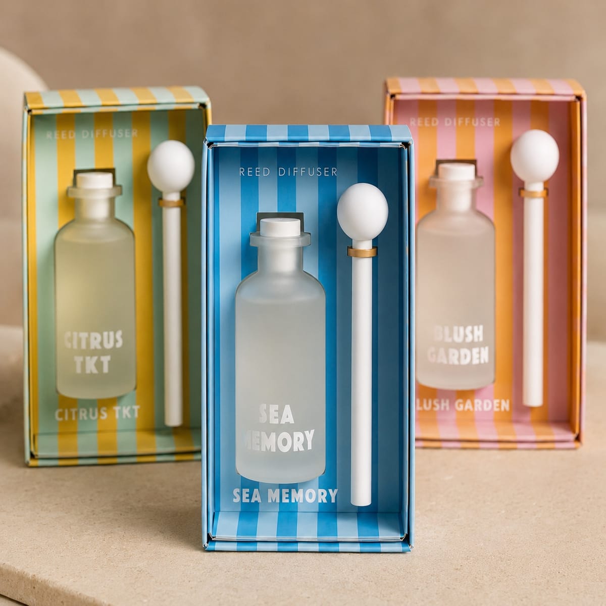 Three colorful striped reed diffuser gift sets in blue, green-yellow, and pink-orange palettes